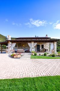 una casa de piedra con un patio de ladrillo frente a ella en Pinelia Home en Mirtófiton