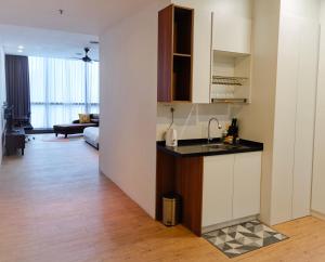 a kitchen with a sink and a living room at The Parkville - Bangsar Trade Centre in Kuala Lumpur