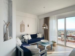 a living room with a blue couch and a table at Villa Elenia in Tsoukalades