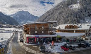 un lodge de esquí con coches aparcados en la nieve en Ferienwohnungen Haus der Mitte, en Mayrhofen