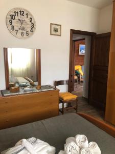1 dormitorio con espejo y reloj en la pared en Casa Angelo en Palau