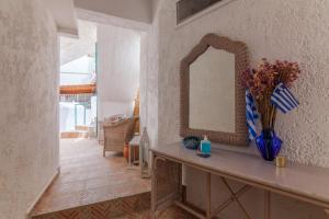pasillo con mesa con espejo y jarrón azul en Guests Apartments in Sissi Creta, en Sissi