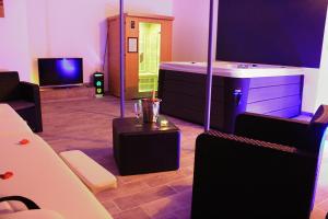a room with a room with a tub and a tv at lemasrocamour in Roquemaure