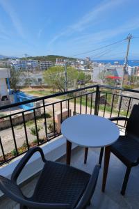 a table and chairs on a balcony with a view of the ocean at Vila Emen in Ksamil