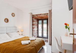 a white bedroom with a large bed and a table at MarbellaTown in Marbella