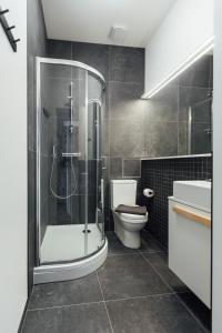 a bathroom with a shower and a toilet and a sink at NEW! Elegant Park Studio with A/C near Old Town in Rīga