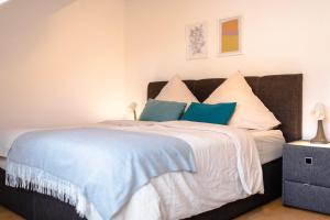 a bedroom with a large bed with blue and white pillows at - NEU - Sweet Home, Parkplatz, Netflix in Bad Salzuflen