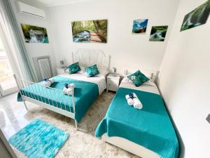 two beds in a bedroom with blue and white at Apartment Savoia in Bari