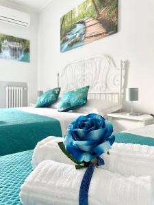 a blue rose sitting on top of two beds at Apartment Savoia in Bari