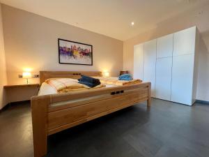 BeckingenにあるJUNIPRO Apartments Haustadtのベッドルーム1室(大型木製ベッド1台付)