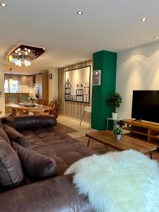 a living room with a couch and a flat screen tv at JUNIPRO Apartments Haustadt in Beckingen