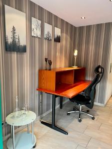 an office with a desk and a chair and a table at JUNIPRO Apartments Haustadt in Beckingen