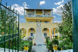 una casa amarilla con una escalera delante de ella en Katerina's Sunset Apartment, en Episkopianá