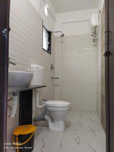 a bathroom with a toilet and a sink at SHRISTI HEIGHT in Kolkata