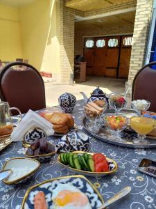 stół z talerzami jedzenia na górze w obiekcie Old Street Guesthouse w mieście Buchara