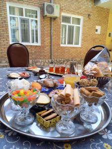 una tavola ricoperta di ciotole di cibo su un tavolo di Old Street Guesthouse a Bukhara