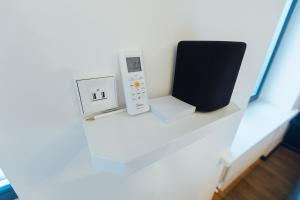a shelf with a remote control and an electronic device at NEW! Elegant Park Studio with A/C near Old Town in Rīga