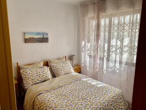 Schlafzimmer mit einem Bett und einem Fenster in der Unterkunft Edificio Laura in San Pedro del Pinatar