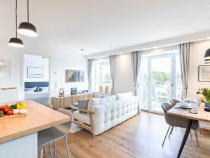 a living room with a white couch and a table at FeWo Prora - Deck54 Dachterrasse in Binz