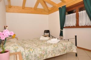 1 dormitorio con cama y ventana en Casa Ornella, en Ledro