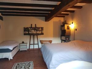 a bedroom with two beds and a painting on the wall at Le Moulin du Châtelier in Paulmy +30 photos
