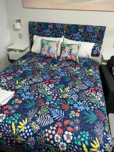 Bett mit bunter Bettdecke und Kissen in der Unterkunft Paradise Palms in Mandurah