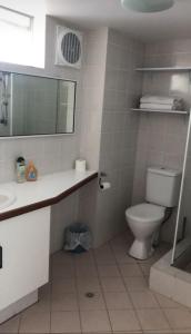 ein Badezimmer mit Toilette, Waschbecken und Spiegel in der Unterkunft Paradise Palms in Mandurah