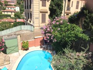una piscina en un patio con flores en Villa-Gaby villa entière et piscine, en Menton
