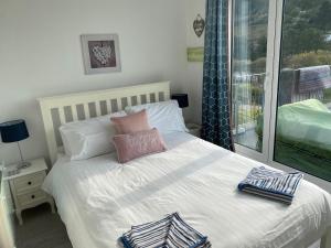 ein Schlafzimmer mit einem Bett mit zwei Kissen darauf in der Unterkunft Bay View, Millendreth Looe Cornwall in Looe