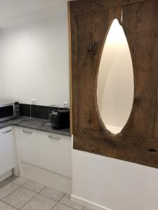 a kitchen with white cabinets and a mirror on the wall at Les Vieille tuiles in Cudos