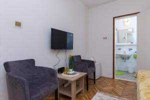 Televízia a/alebo spoločenská miestnosť v ubytovaní Sunset Bay Room