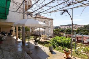 eine Terrasse mit einem Sonnenschirm in einem Gebäude in der Unterkunft Sunset Bay Room in Dubrovnik