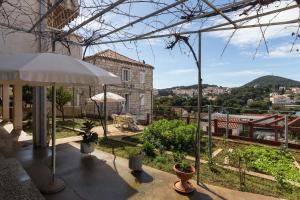 a patio with an umbrella and a view of a city at Sunset Bay Room in Dubrovnik