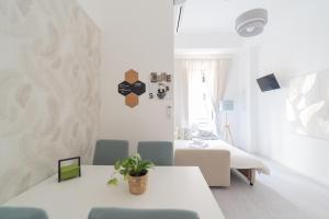 a white living room with a table and chairs at White Gioberti Apartments in Rome