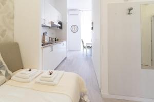 a white room with a bed and a kitchen at White Gioberti Apartments in Rome