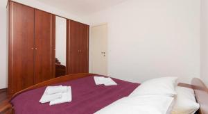 a bedroom with a bed with white towels on it at Apartments Nikolina in Split