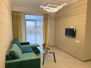 sala de estar con sofá, mesa y TV en Uparthotel en Tsaghkadzor