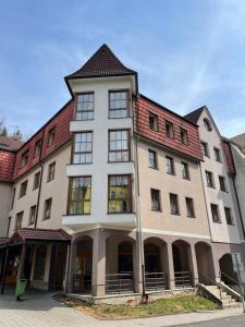 a large white building with a red roof at Apartmány U Pošty in Jáchymov