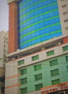 a tall building with green and blue windows at Hotel Victory - Best in City Center in Dhaka
