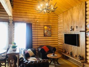 a living room with a couch and a television at Kecharis Hotel and Resort in Tsaghkadzor