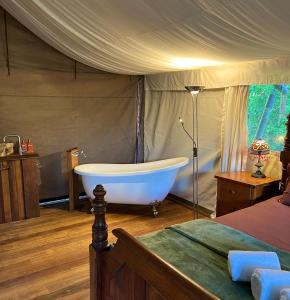 a bedroom with a tub in a tent at Silk Pavilions Glamping in Mount Burrell