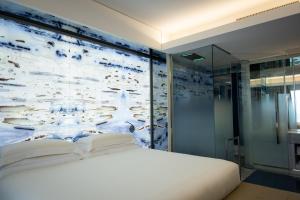 un letto bianco in una camera con murale di Ghibli Hotel a Civitanova Marche