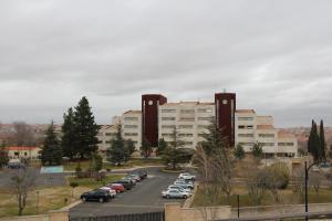 un estacionamiento con autos estacionados frente a un edificio en Hotel Eurowest, en Salamanca