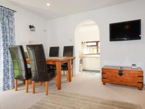 uma sala de jantar com uma mesa de madeira e cadeiras em Blue Bell Cottage em St Austell