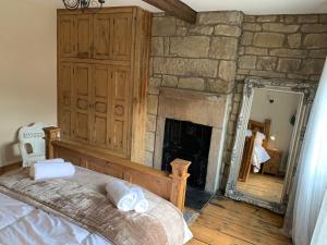 a bedroom with a stone fireplace and a bed at Meg's Den in Hebden Bridge