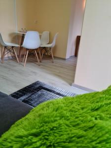 - un salon avec un tapis vert, une table et des chaises dans l'établissement Pension Kreihe im Harz, à Bad Lauterberg