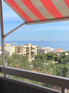einen Balkon mit Stadtblick und einem Sonnenschirm in der Unterkunft Casa Cometa - vista mare in Monopoli