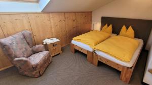 ein Schlafzimmer mit einem Bett und einem Stuhl in der Unterkunft City Apartment Hornblick in Kitzbühel
