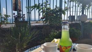 una botella de soda sentada en una mesa con tazas en Hotel Lozite, en Sozopol