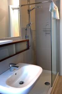 W łazience znajduje się umywalka i przeszklony prysznic. w obiekcie Dante 12 w mieście Vigevano